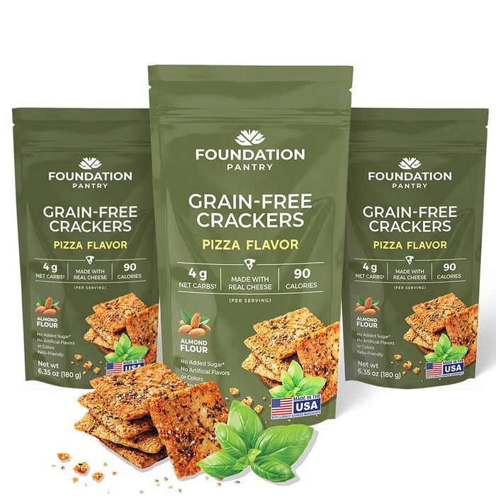 A few seeded crackers displayed next to three packages of Foundation Pantry Grain-Free Crackers in the pizza flavor.