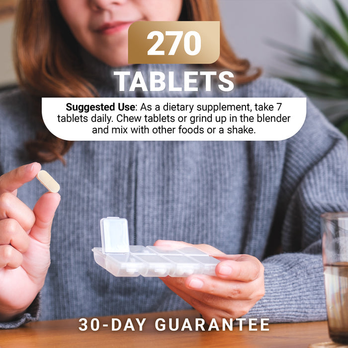 Person holding a small container of tablets with text: '270 tablets. Suggested Use: As a dietary supplement, take 7 tablets daily. Chew tablets or grind up in the blender and mix with other foods or shake. 30-day guarantee'.